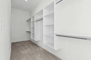 Walk in closet featuring light colored carpet