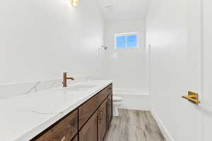 Bathroom with vanity, light wood-style floors, and bathing tub / shower combination