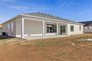 Rear view of property with a patio and a shingled roof