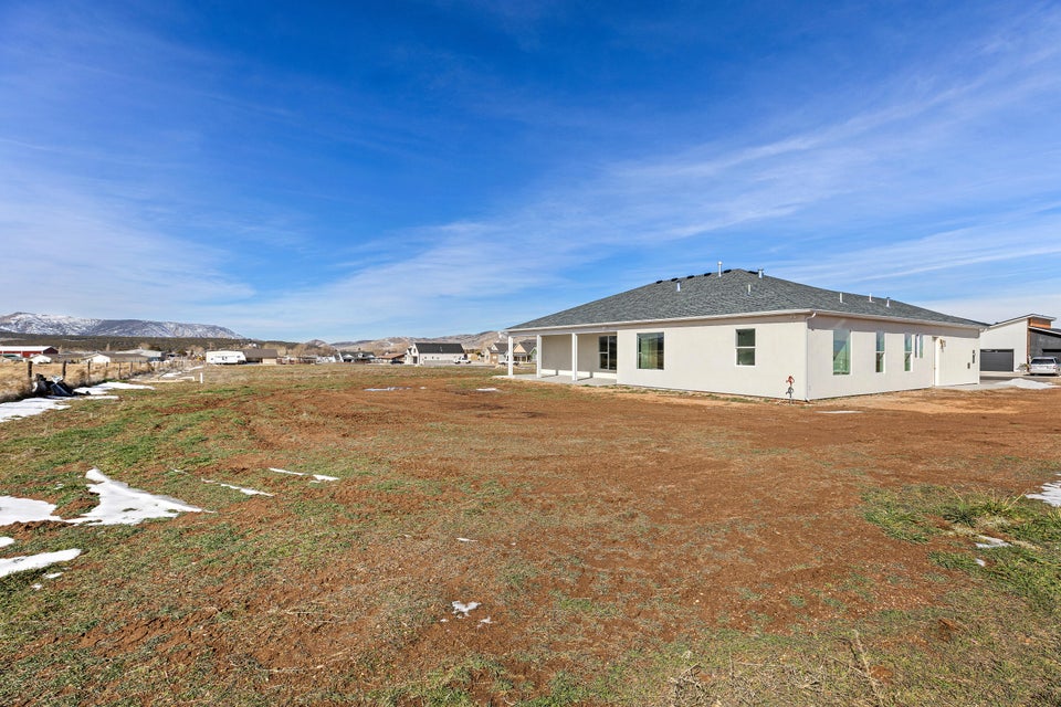 Rear view of property with a patio, a shingled roof, a mountain view, and stucco siding