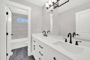 Main bath with large vanity, double sinks and private tub / toilet area.