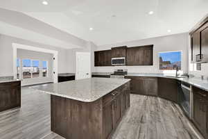 Large island with granite countertop and seating space.