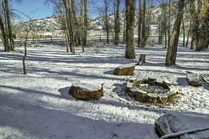 Yard layered in snow with an outdoor fire pit