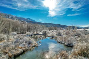 View of mountain background with a nearby body of water and a heavily wooded area