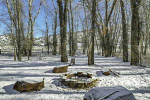 Yard covered in snow with an outdoor fire pit