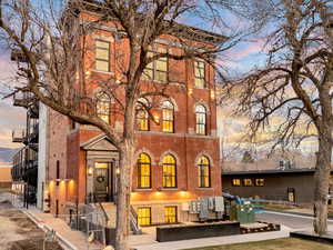 Back of property at dusk with brick siding and stairway