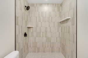 Full bathroom with toilet and a tile shower