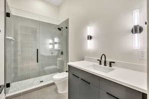 Bathroom featuring vanity, a shower stall, and light tile patterned floors