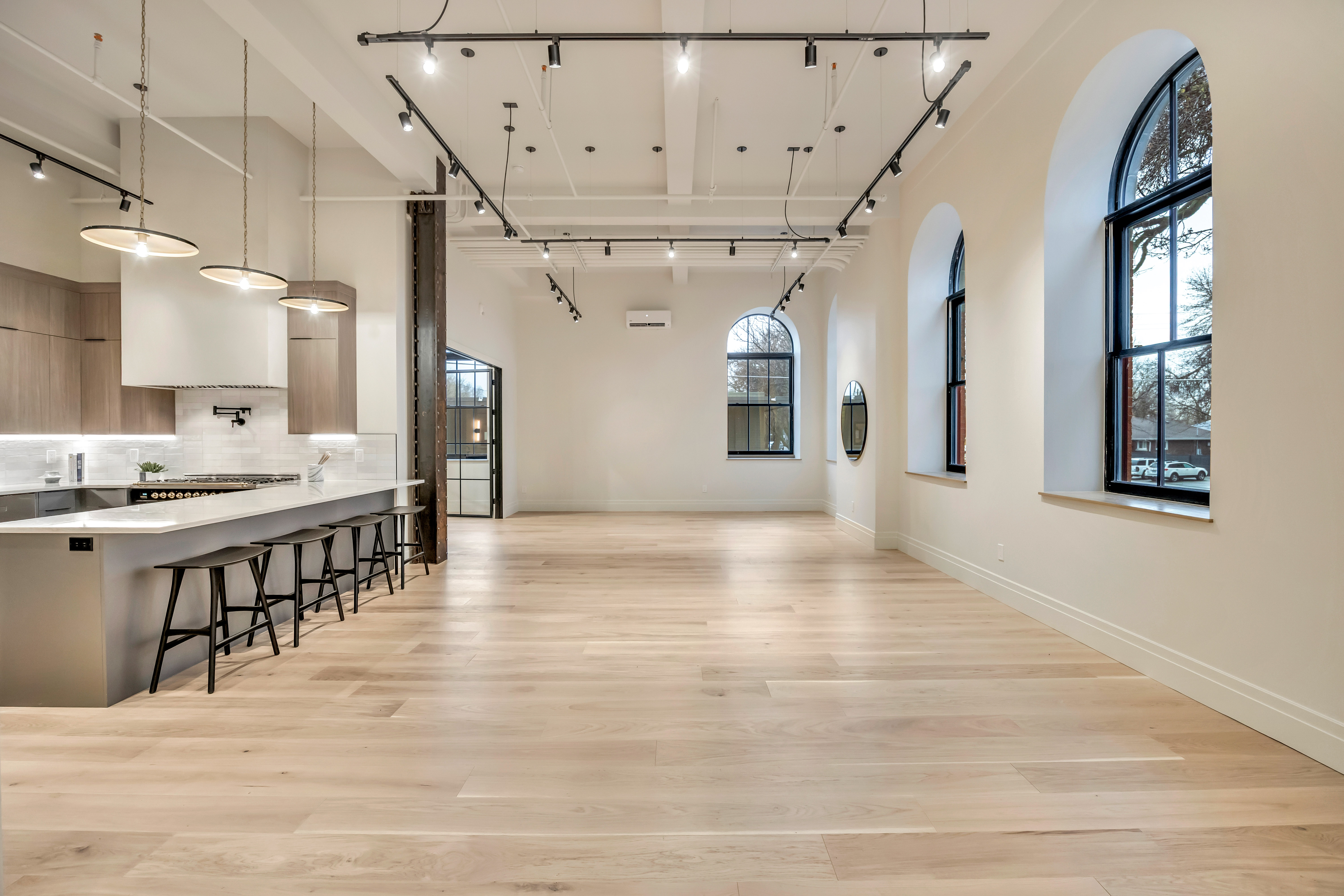 Dining area featuring rail lighting, a high ceiling, and light wood finished floors