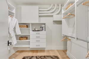 Walk in closet featuring light wood-style flooring