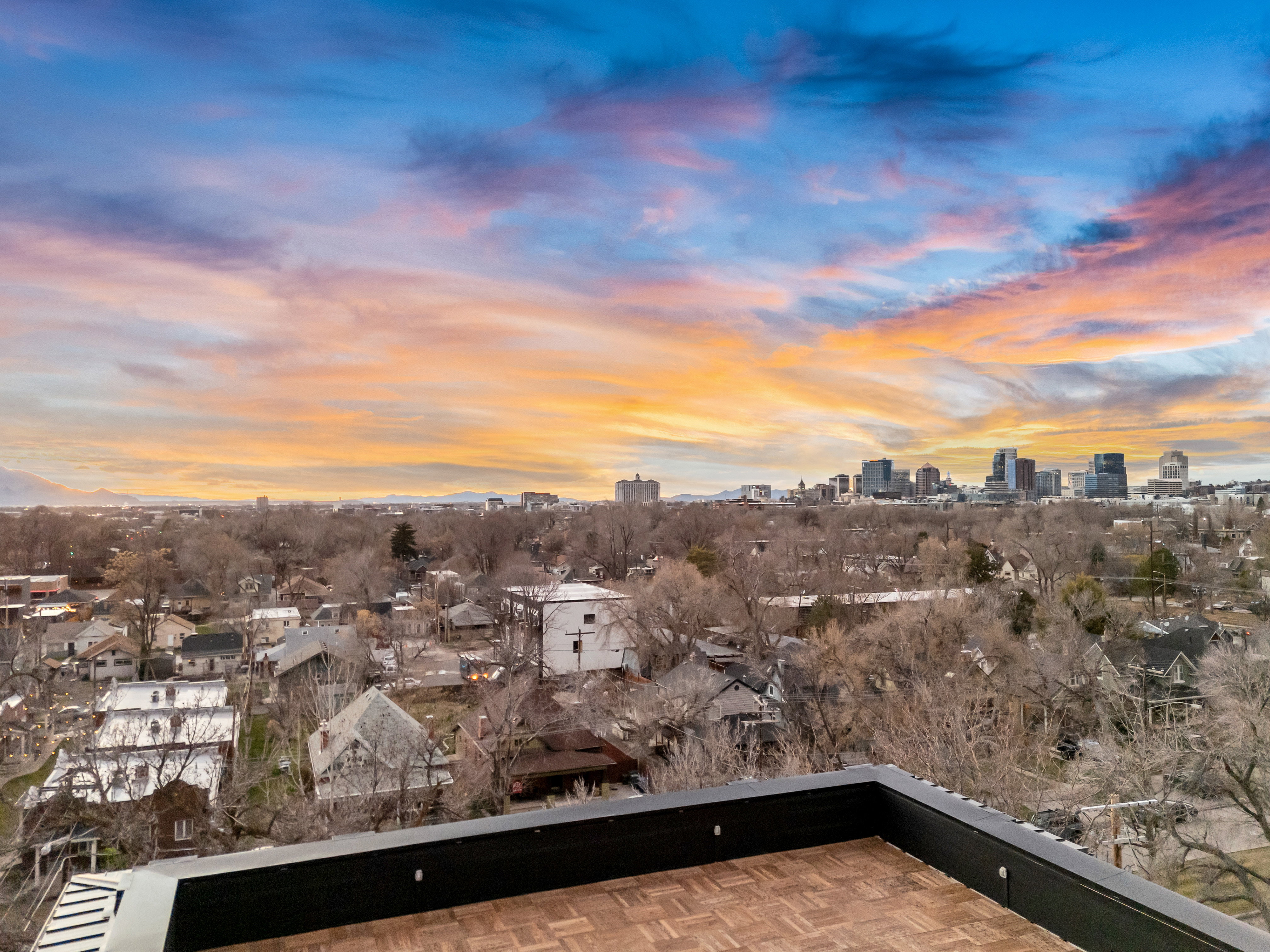 Balcony at dusk featuring a view of skyline and a patio