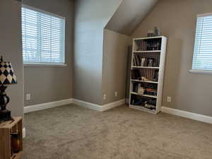 Bonus room featuring light colored carpet, lofted ceiling, and plenty of natural light