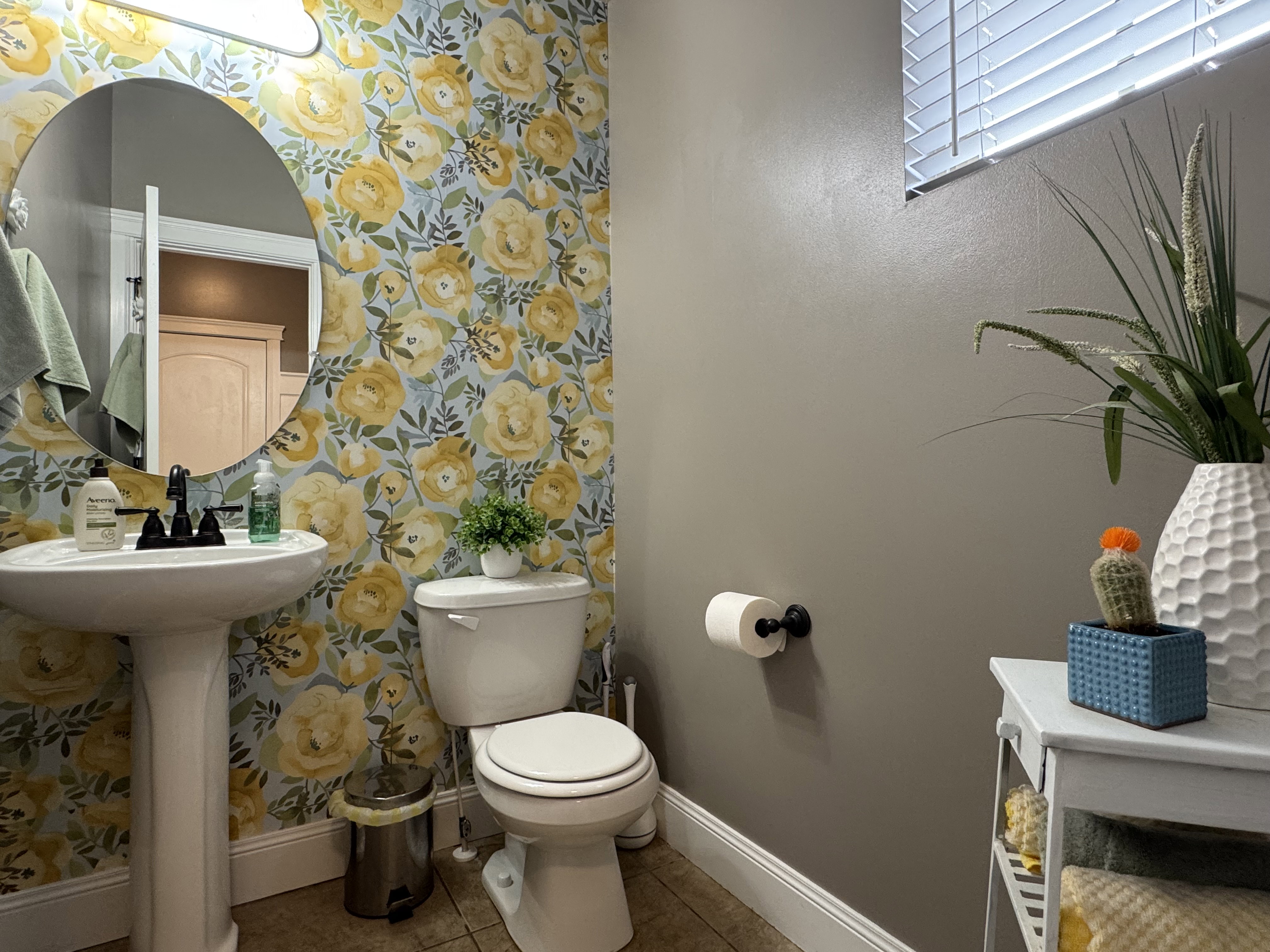 Half bath featuring light tile patterned floors and wallpapered walls