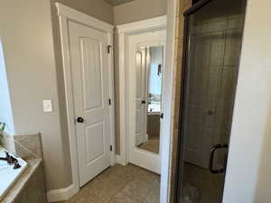 Full bath with a garden tub, a shower stall, and light tile patterned flooring
