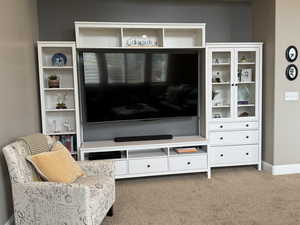 Living area with light carpet and baseboards