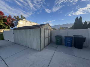 View of shed with a mountain view and a fenced backyard