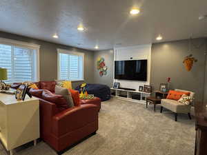 Carpeted living area with a textured ceiling and recessed lighting