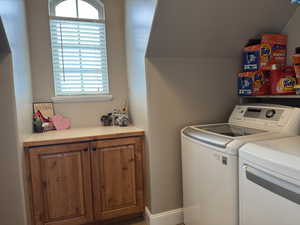 Laundry area featuring washer and dryer, plenty of natural light, and vaulted ceiling