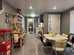 Carpeted dining room with recessed lighting