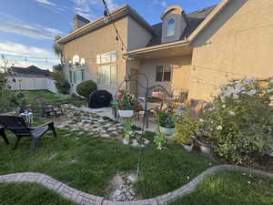 Rear view of house featuring stucco siding, a patio, and a chimney