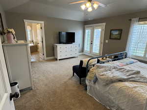 Bedroom with french doors, light colored carpet, multiple windows, access to exterior, and lofted ceiling