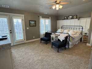 Bedroom with access to outside, light colored carpet, and a ceiling fan