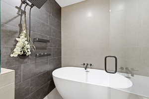 Bathroom with a freestanding tub and tile walls