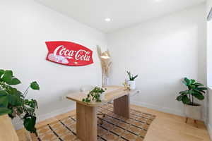Office space featuring light wood-type flooring and recessed lighting