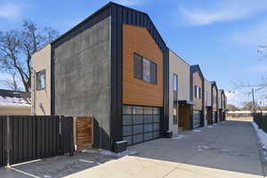 View of side of home with a garage, concrete driveway, stucco siding, and board and batten siding