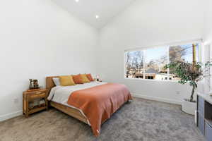 Carpeted bedroom with vaulted ceiling and recessed lighting
