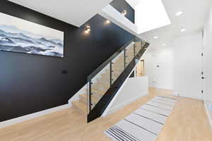 Stairway with wood finished floors and recessed lighting