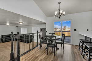 Dining room with suspended lighting, lofted ceiling, and light wood finished floors