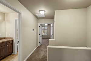 Corridor with light carpet and a textured ceiling.French doors leading to master bath.
