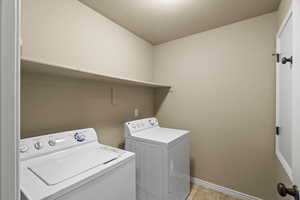 Laundry room with washing machine and clothes dryer and light tile patterned floors