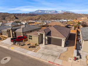 View of front of property featuring a garage, a residential view, stucco siding, concrete driveway, and a mountain view