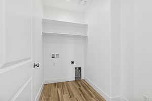 Laundry area with wood tiled floors, hookup for an electric dryer, and washer hookup