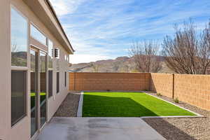 Fenced backyard with a mountain view and a patio area