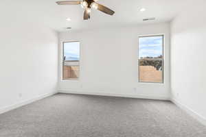Carpeted empty room with a ceiling fan and recessed lighting