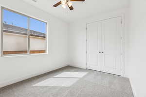 Unfurnished bedroom with light carpet, a closet, and ceiling fan