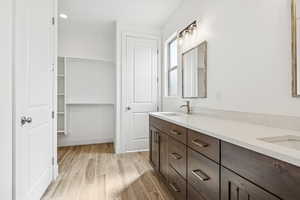 Full bath with wood tiled floors and double vanity