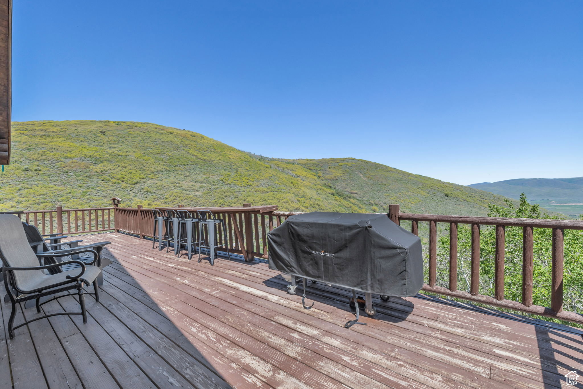 Wooden deck featuring a mountain view and a grill