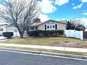 View of front of house with a gate, brick siding, a garage, and driveway