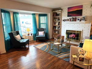 Living area featuring a brick fireplace and wood finished floors
