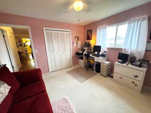 Office area featuring light colored carpet and ceiling fan