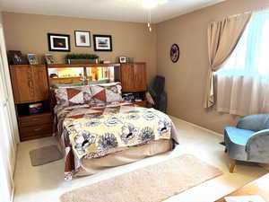 Carpeted bedroom featuring baseboards and ceiling fan