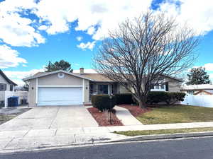 Ranch-style house featuring brick siding, a garage, driveway, and a chimney