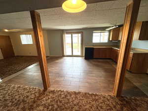 Kitchen with open floor plan, wood finish cabinets, black dishwasher, and plenty of natural light