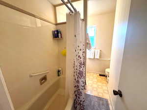 Full bath featuring light flooring and shower / bath combo