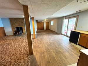Basement with a wood stove, light wood finished floors, and wood walls
