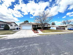 Single story home featuring concrete driveway and a garage